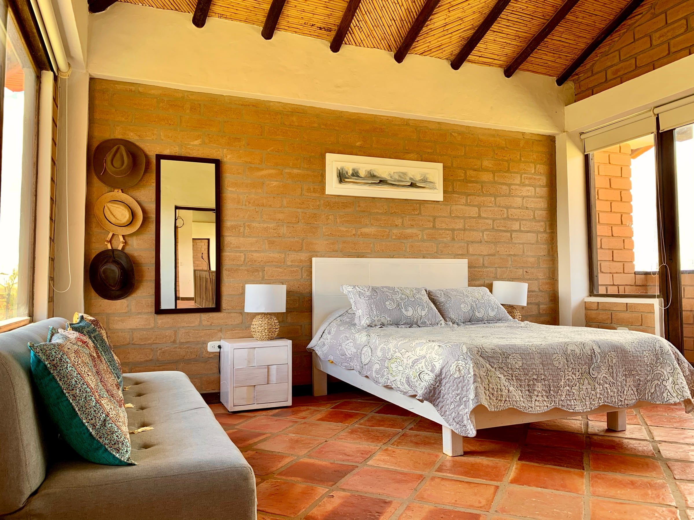 Habitación con muro interior de bloque de tierra comprimida a la vista y cubierta de madera