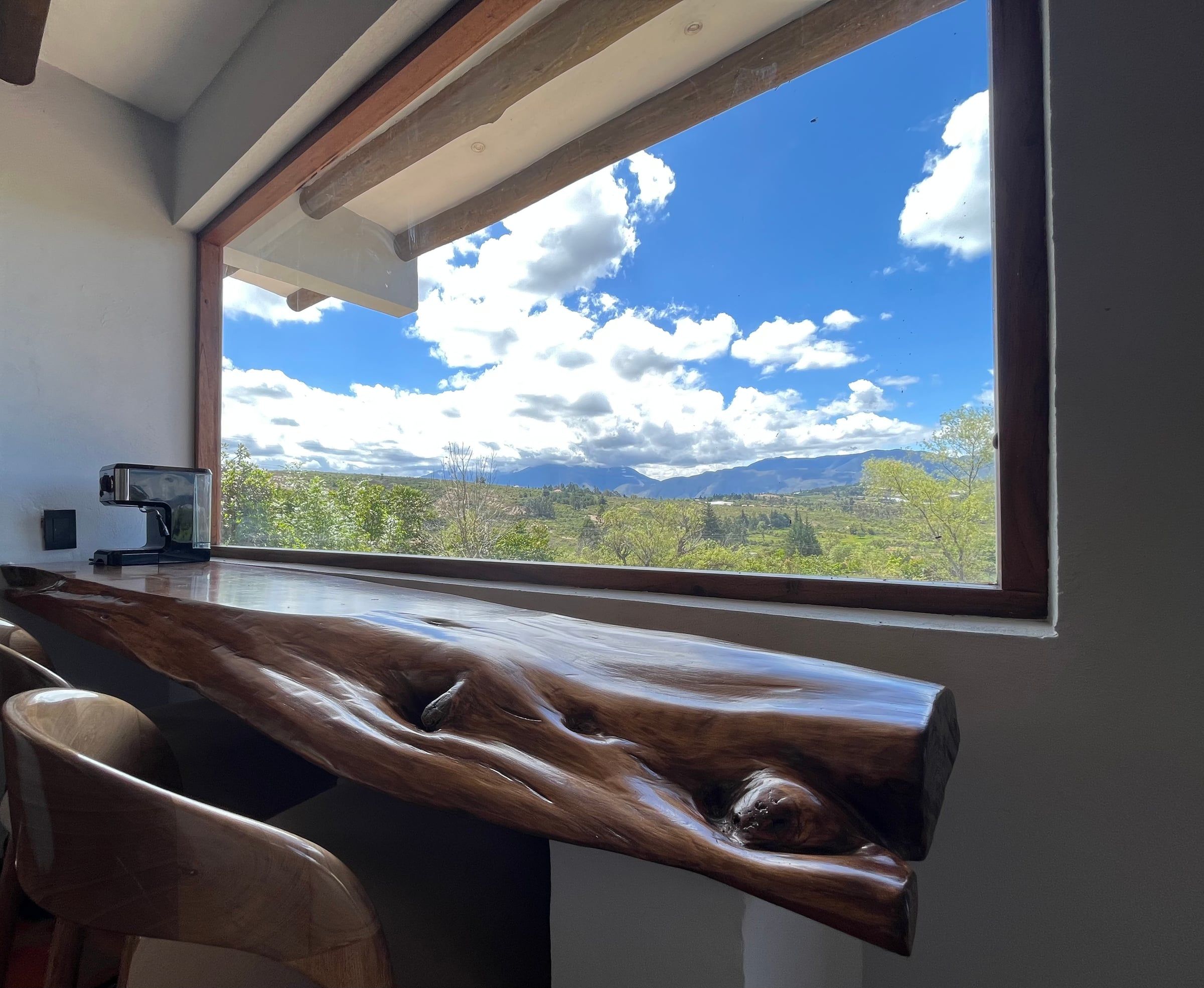 Barra de madera natural bajo una ventana amplia con vista a las montañas